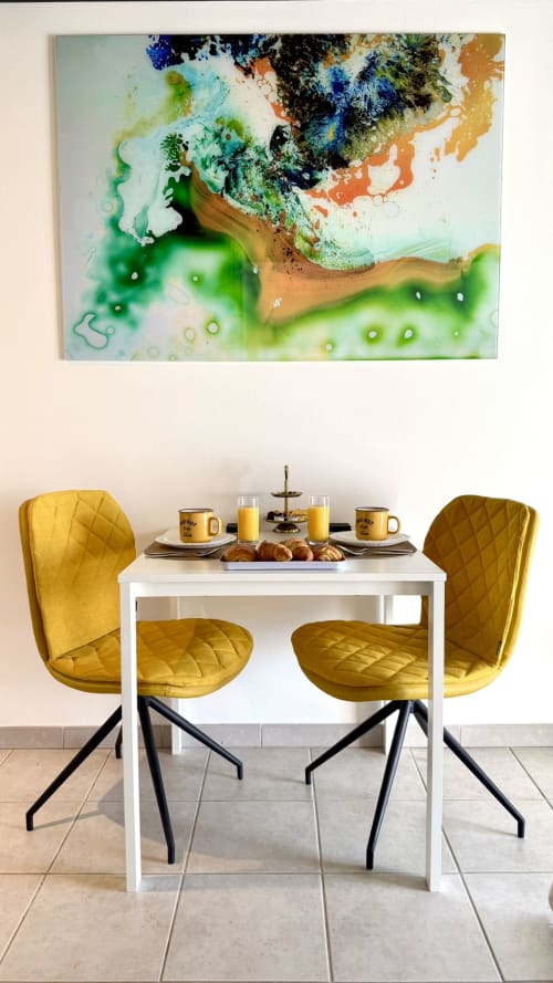 Modernes Esszimmer in einem Cannes-Apartment mit gelben gesteppten Stühlen, weißem Tisch und farbenfrohen abstrakten Kunstwerken an der Decke