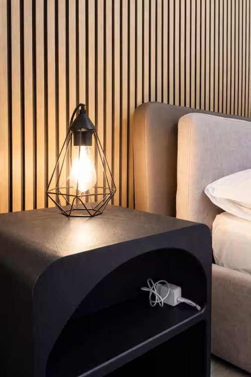 Comodino moderno con lampada geometrica nera e ripiano aperto, Suite169 Bari con parete a righe