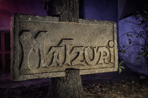 Rótulo de piedra tallada del hotel rural Matzuri Nekazalturismoa en Mutriku, España, iluminado por la noche