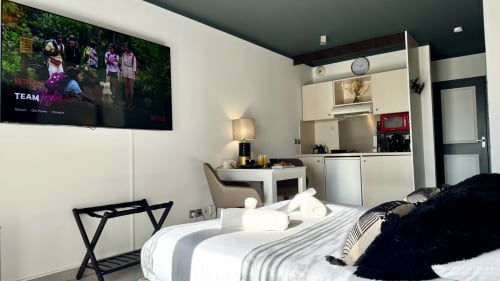 Modernes Studio-Schlafzimmer im Château des Artistes in Le Cannet mit Flachbildfernseher, weißem Bett, Kochnische und Arbeitsbereich