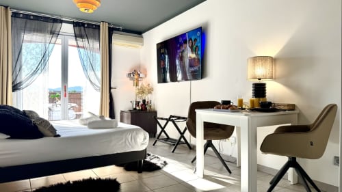 Monolocale moderno a Château des Artistes a Le Cannet con letto, scrivania, vista sulla città, TV e arredi contemporanei