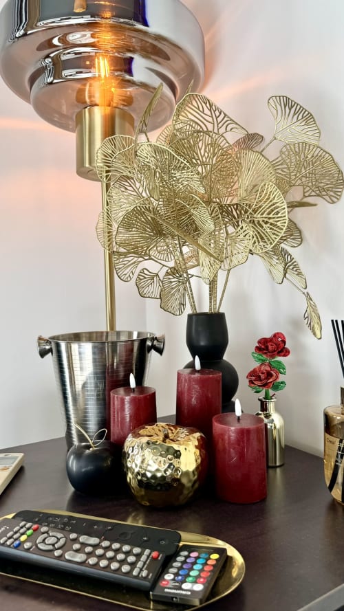 Elegante Schreibtischeinrichtung in der Résidence Château des Artistes mit goldenem Ginkgo, burgunderfarbenen Kerzen und leuchtender Lampe