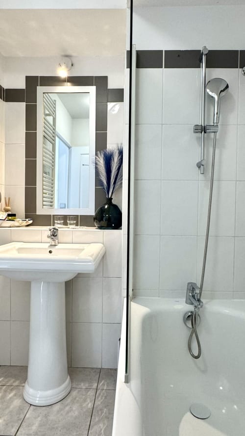 Modernes Badezimmer in der Résidence Château des Artistes mit Säulenwaschtisch, Rahmenspiegel und begehbarer Dusche mit Haltegriff