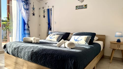 Nautisch gestaltetes Schlafzimmer in der Résidence Château des Artistes mit Queensize-Bett, blauen Akzenten und Seestern-Dekoration