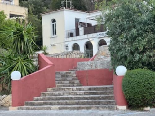 Rote Treppe am Eingang der Résidence Château des Artistes in Le Cannet mit weißem Gebäude und mediterraner Gartengestaltung