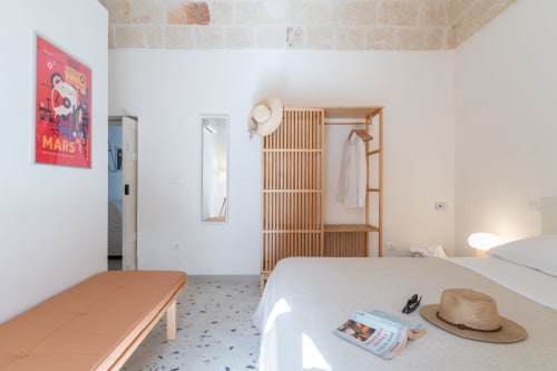 Suite Alimede dell'hotel Trulli Life a Bari. Camera moderna con guardaroba in legno, pavimenti in terrazzo e design minimalista