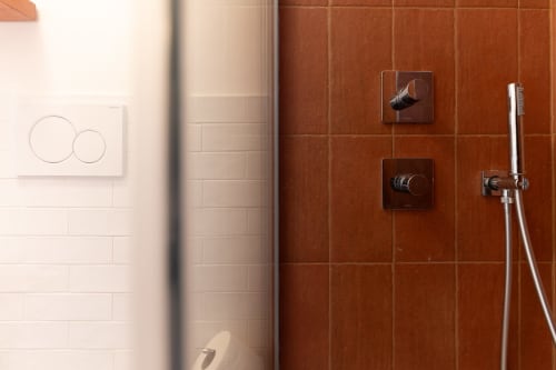 Moderni accessori da bagno nella Suite Alimede dell'hotel Trulli Life a Bari, con piastrelle in terracotta e doppi comandi