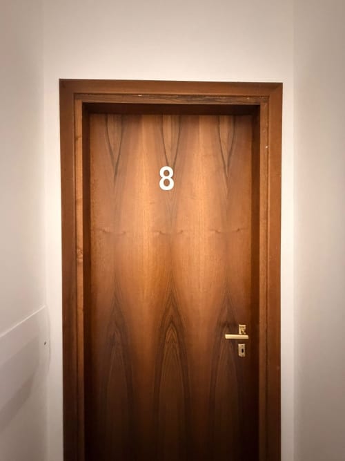Porta in legno numero 8 con maniglia dorata in camera tripla 2 dell'hotel TMS, Mestre Italia