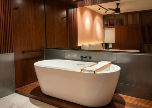 Baño de lujo moderno en Villa Merida Boutique Hotel con bañera exenta blanca, detalles de madera e iluminación ambiental