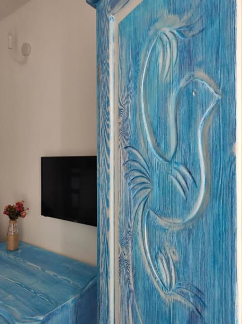 Porta blu dal design artistico nella suite Regnos Altos Boutique Room a Bosa, con TV e decorazioni floreali
