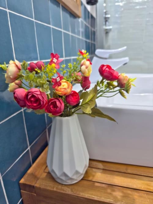 Splendido bouquet di rose rosse e arancioni in vaso bianco presso Regnos Altos Boutique Rooms, Bosa