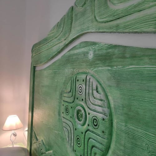 Testata verde in legno con dettagli ornamentali intagliati nella Camera Tripla Comfort di Regnos Altos Boutique Rooms, Bosa