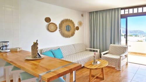 Sala de estar moderna em Apartamentos Gelimar, Porto Rico com vista da piscina, móveis de madeira e decoração de parede tecida