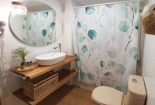 Banheiro moderno em Apartamentos Gelimar Puerto Rico com pia, vaso sanitário e cortina de chuveiro com folhas de eucalipto