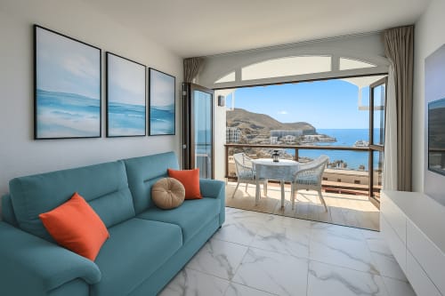 Apartamento Guayarmina 201 em Gelimar Porto Rico - sofá turquesa, varanda com vista para o mar e cidade litorânea