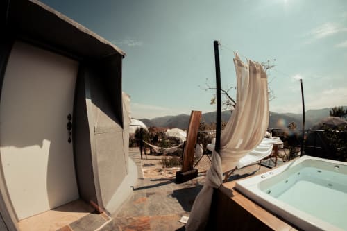 Terraza en la azotea de Meraki Glampings en Malinalco con bañera de hidromasaje, hamaca y vistas a la montaña