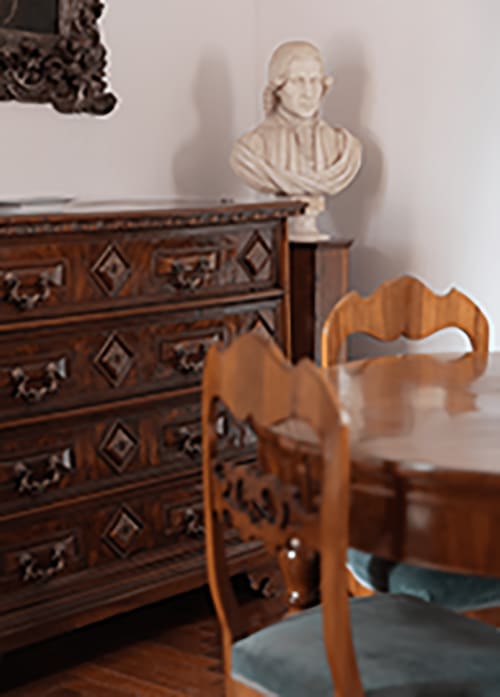 Elegant wooden furniture with carved chair and ornate dresser in Cristallo Apartment, Ravenna