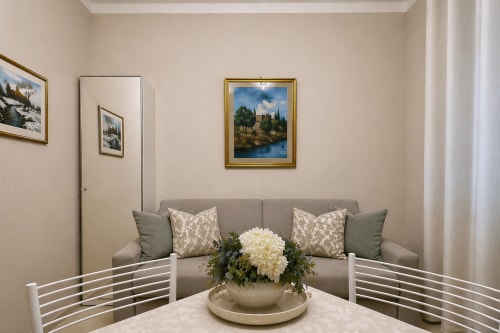 Elegant Verona apartment living room with grey sofa, decorative pillows, and white hydrangea centerpiece