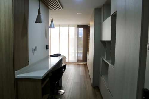 Moderno apartaestudio en Modelia Living Bogotá con escritorio, TV de pantalla plana, luces colgantes y vistas a la ciudad