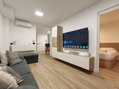 Moderna sala de estar en Bahia Mar Canarias con televisor, asientos confortables y acceso al dormitorio