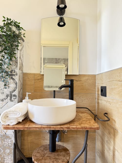 Bagno moderno del B&B Luna Verde con lavabo bianco, rubinetto nero, mobile in legno e specchio con illuminazione.