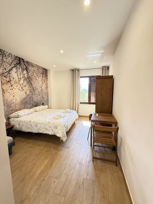 Camera moderna del B&B Luna Verde con letto matrimoniale, armadio in legno, scrivania e vista sulle montagne dalla finestra