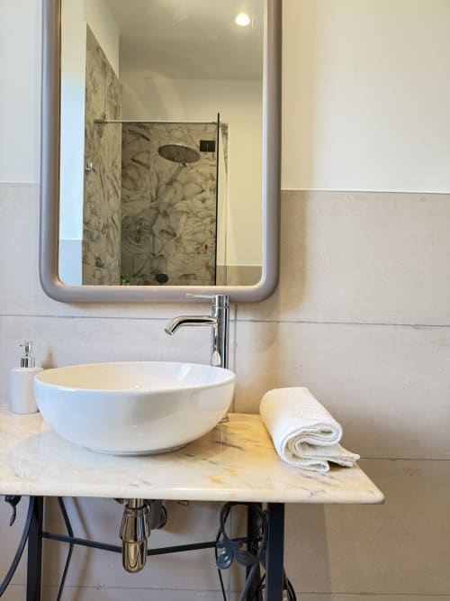 Lavabo moderno con bacinella bianca, rubinetto cromato e specchio illuminato presso B&B Luna Verde