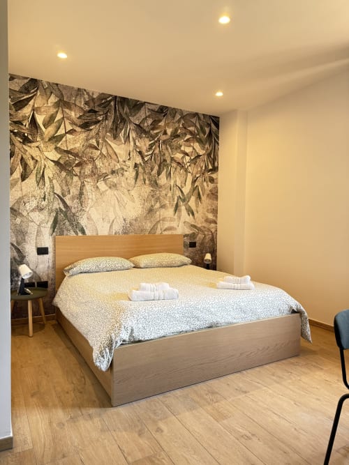 Camera moderna della Luna Verde B&B con letto in legno, murale botanico e illuminazione da giardino