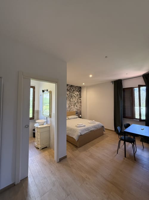 Ampia camera doppia al B&B Luna Verde con vista giardino, letto, angolo cottura, scrivania e bagno ensuite