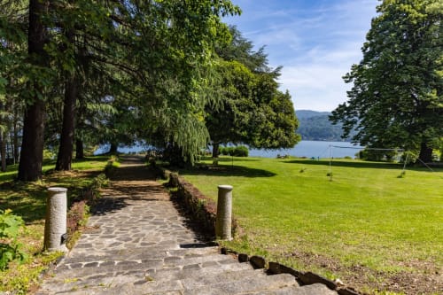 Sentiero in pietra attraverso rigogliosi giardini verso il Lago d'Orta presso Lake Orta Retreat villa a San Maurizio D'Opaglio, Italia