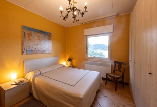 Camera da letto giallo brillante con vista sul lago presso la villa Lake Orta Retreat a San Maurizio d'Opaglio, Italia