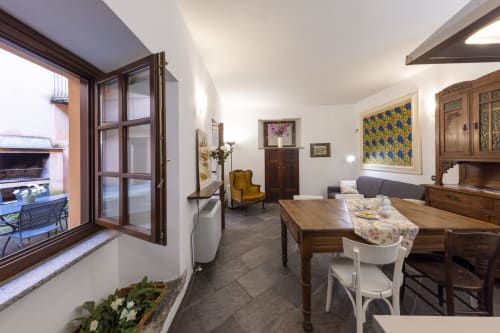 Ampia zona living in cortile con arredamenti in legno, camino e accesso al patio - Lake Orta Retreat