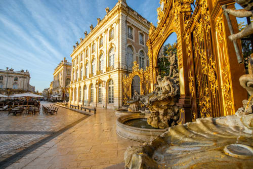 Façade de palais ornée de dorures avec fontaines sculptées sur la place historique près de Rosières aux Salines