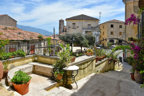 Terrazza panoramica della B&B Luna Verde con piante, area lounge e lo sfondo dell'architettura del borgo italiano
