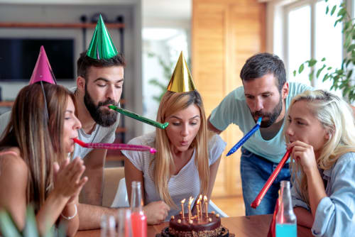 Des amis célèbrent une fête d'anniversaire à la Maison Agami B&B à Rosières aux Salines avec gâteau et chapeaux de fête