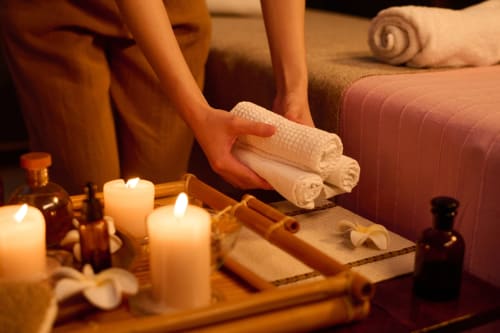 Ambiance spa détente à la Maison Agami avec serviettes roulées, bougies et huiles à Rosières aux Salines