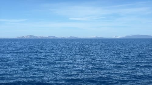 Vista sul mare azzurro con isole lontane da Stintino, Pescaturismo Lia, Sardegna
