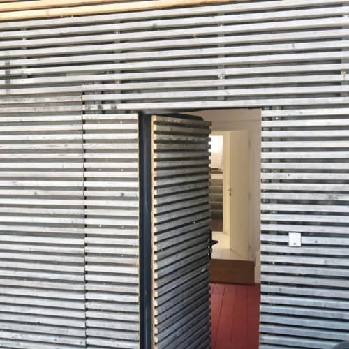 Entrée moderne avec porte à lames du gîte Denis & Virginie à Versailles, design intérieur contemporain visible