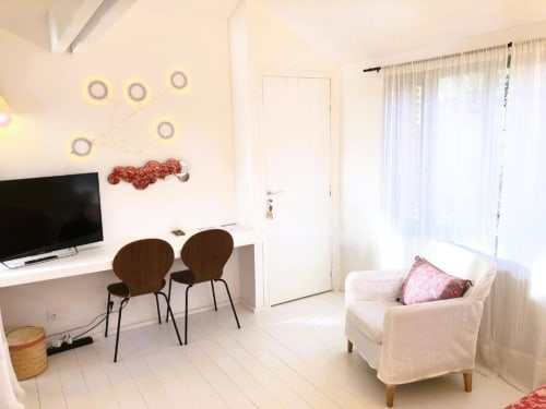 Chambre double lumineuse au gîte Denis & Virginie à Versailles avec espace de travail, fauteuil crème et portes-fenêtres sur balcon