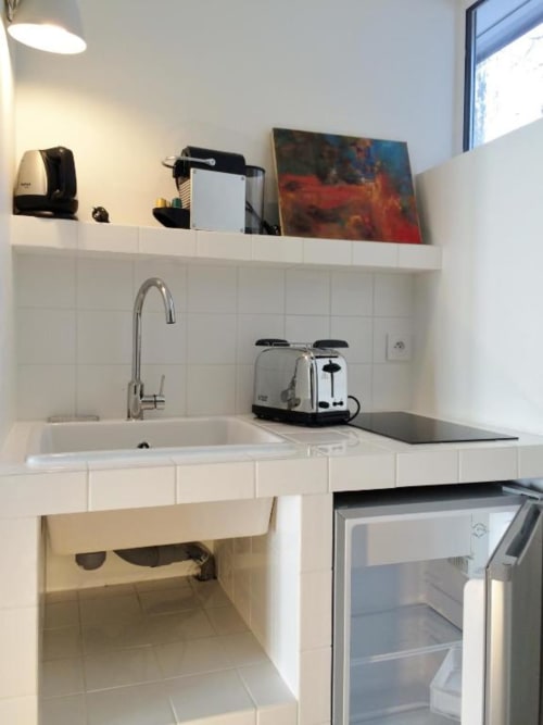 Petite kitchenette blanche moderne dans le studio Denis & Virginie à Versailles avec évier, grille-pain et mini réfrigérateur