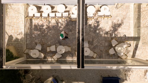 Aerial view of outdoor terrace at Hôtel Le Sud in Juan Les Pins with dining tables and lounge chairs