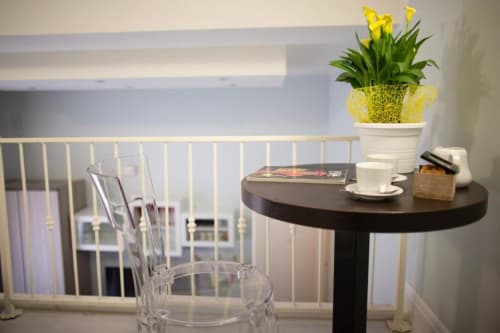 Modern Junior Suite at Exclusive Domus Gaudia Roma with city view, round black table, yellow flowers, and contemporary