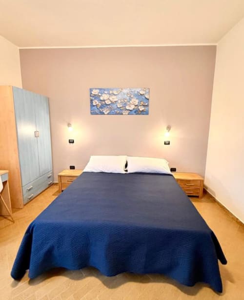 Bedroom in Appartamento Chiara at Hotel Il Mulino, Villalunga, with blue bedding and wooden nightstands