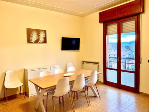 Bright dining area in Appartamento Chiara at Hotel Il Mulino, Villalunga, with wooden table, white chairs, and balcony view