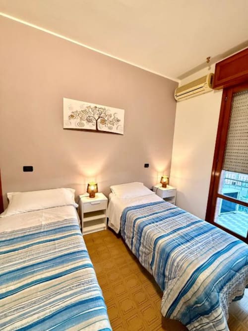 Twin bedroom in Appartamento Chiara at Hotel Il Mulino, Villalunga, with blue striped bedding and modern amenities