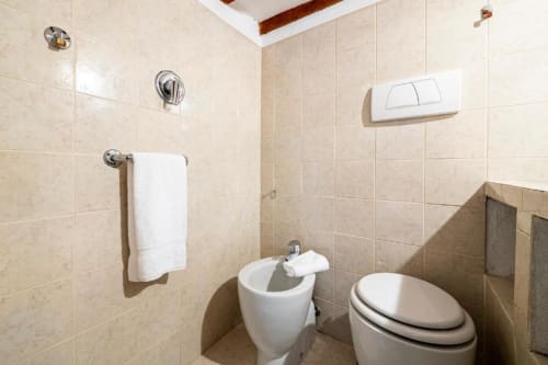 Bagno moderno presso Bronze Horse Affittacamere a Firenze con piastrelle, toilet, bidet e portasciugamani