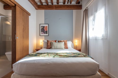 Camera da letto in penthouse con vista sul Colosseo a Roma, travi in legno, parete blu e vista sulla città