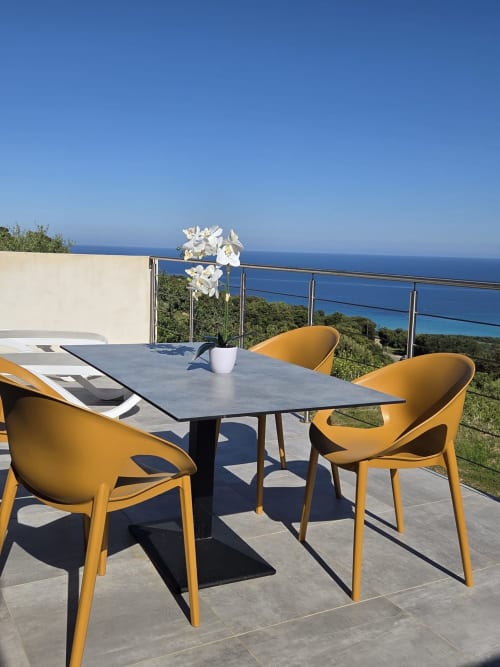 Terrasse moderne avec chaises jaunes surplombant la mer Méditerranée à la Résidence Lésia, Corbara