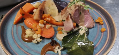 Elegant plated duck breast with roasted carrots, cauliflower, and seasonal vegetables at Auberge du Pont de l'Alp, Le