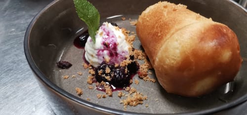 Gourmet dessert plate at Auberge du Pont de l'Alp: pastry, berry compote, crumble, cream, and edible flowers in Le